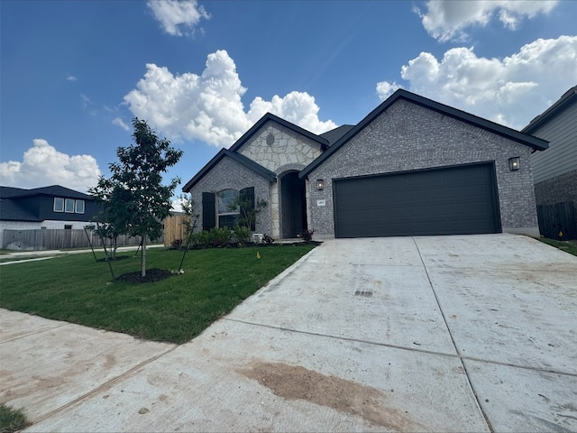 493 Sugar Cane Rd, Buda, TX 78610 - french country home featuring concrete driveway, a garage, and brick siding