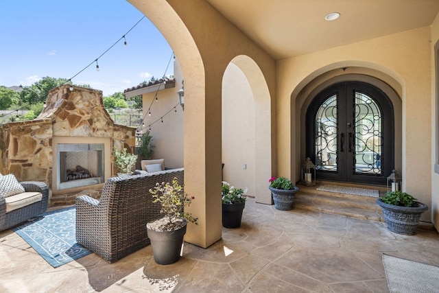 1306 High Lonesome, Leander, TX 78641 - entrance to property with an outdoor stone fireplace, french doors, stucco siding, and a patio