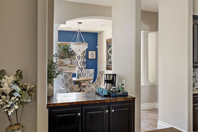 1306 High Lonesome, Leander, TX 78641 - bar area with arched walkways, baseboards, decorative columns, and pendant lighting