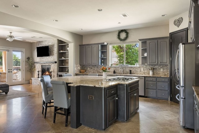 1306 High Lonesome, Leander, TX 78641 - kitchen featuring open shelves, open floor plan, stainless steel appliances, ceiling fan, and tasteful backsplash