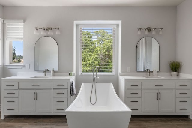 1306 High Lonesome, Leander, TX 78641 - full bathroom with wood tiled floors, two vanities, and a freestanding bath