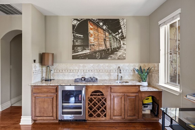 1306 High Lonesome, Leander, TX 78641 - indoor wet bar with beverage cooler, dark wood finished floors, arched walkways, and decorative backsplash
