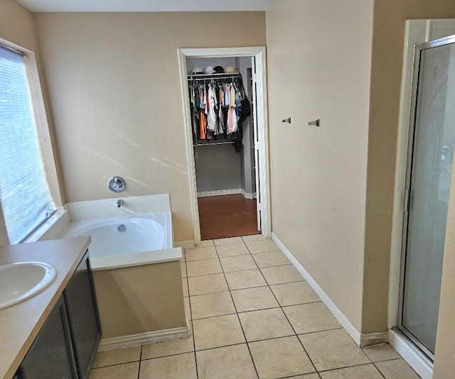 14400 Little Eagle Ct, Elgin, TX 78621 - bathroom featuring a stall shower, a healthy amount of sunlight, tile patterned flooring, and a spacious closet
