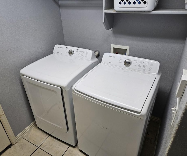 14400 Little Eagle Ct, Elgin, TX 78621 - clothes washing area with light tile patterned floors, baseboards, washer and dryer, and laundry area