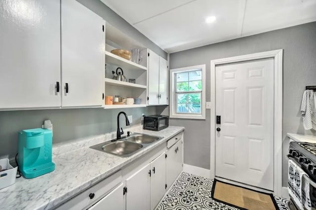 1026 Haynes St Unit 28, San Marcos, TX 78666 - kitchen with gas range, white cabinetry, open shelves, and black microwave