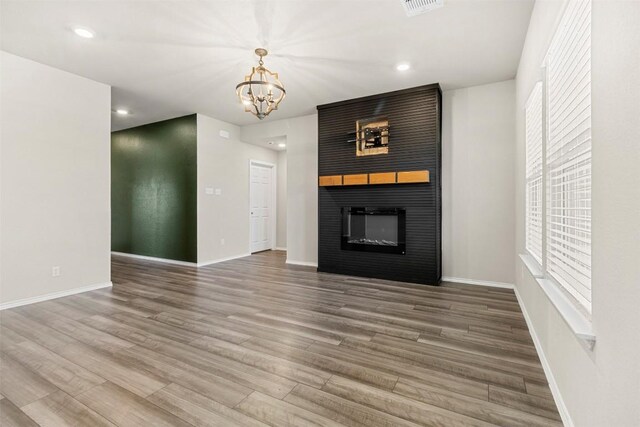 8516 Cantera Ridge Rd, Temple, TX 76502 - unfurnished living room featuring a large fireplace, a chandelier, wood finished floors, baseboards, and recessed lighting