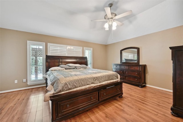 bedroom featuring baseboards, light wood finished floors, lofted ceiling, and ceiling fan