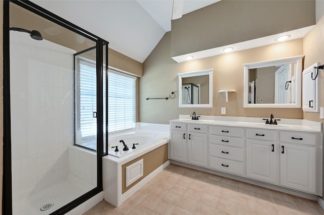 bathroom with lofted ceiling, a stall shower, a garden tub, double vanity, and tile patterned floors