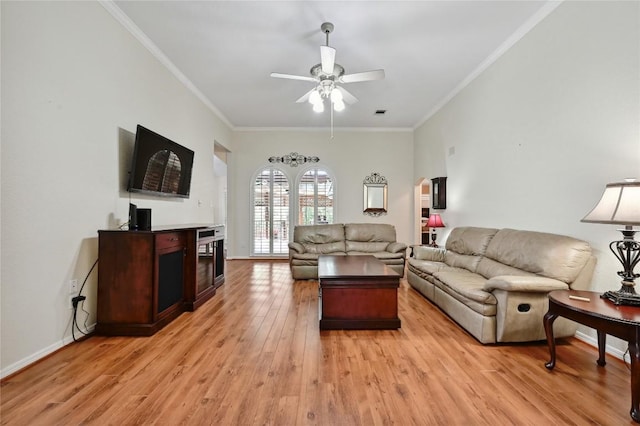 living room featuring a ceiling fan, light wood finished floors, crown molding, and a fireplace
