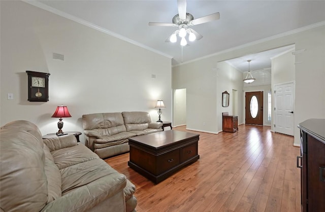 living room with a ceiling fan, light wood finished floors, crown molding, and baseboards