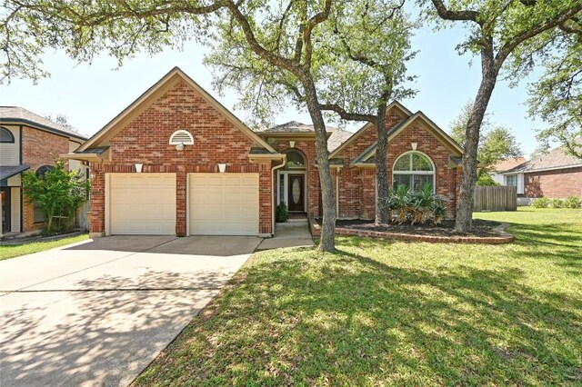 traditional-style house with a garage, driveway, and brick siding