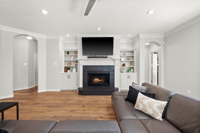 3420 Benecia Ct, Austin, TX 78738 - living room featuring arched walkways, light wood-style floors, a ceiling fan, recessed lighting, and ornamental molding