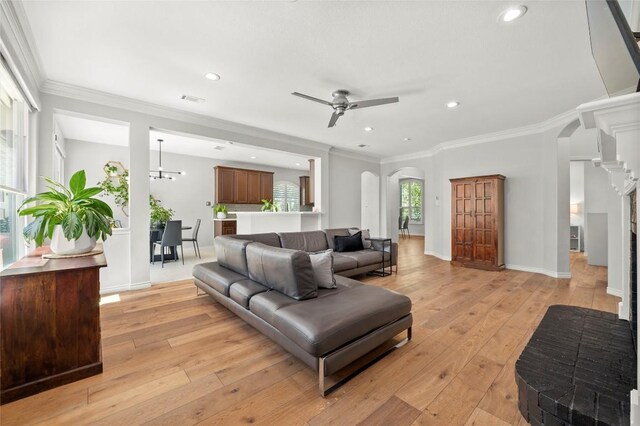 3420 Benecia Ct, Austin, TX 78738 - living room featuring arched walkways, light wood finished floors, ceiling fan, recessed lighting, and crown molding