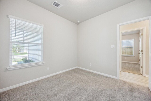unfurnished room with carpet, baseboards, and lofted ceiling