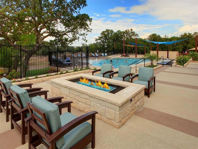 community pool featuring an outdoor fire pit, fence, and a patio area