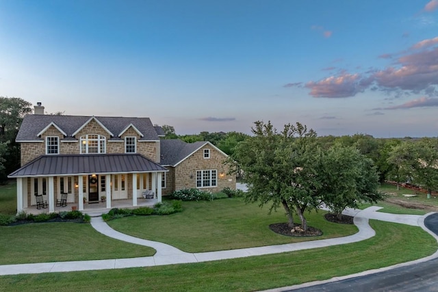 104 Double Cir, Burnet, TX 78611 - view of front of home with a standing seam roof, covered porch, a yard, and stone siding