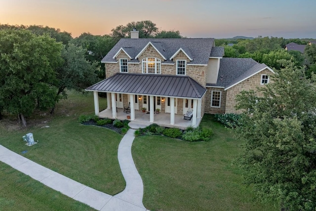 104 Double Cir, Burnet, TX 78611 - view of front of property featuring stone siding, covered porch, a standing seam roof, a front yard, and a chimney