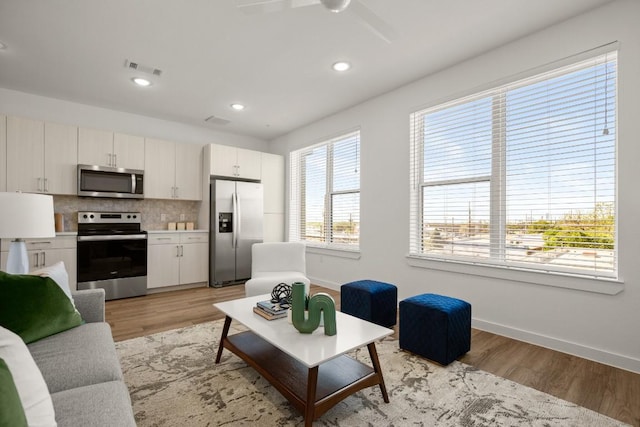 6324 N Lamar Blvd Unit 313, Austin, TX 78752 - living room featuring light wood-style flooring, baseboards, a ceiling fan, and recessed lighting