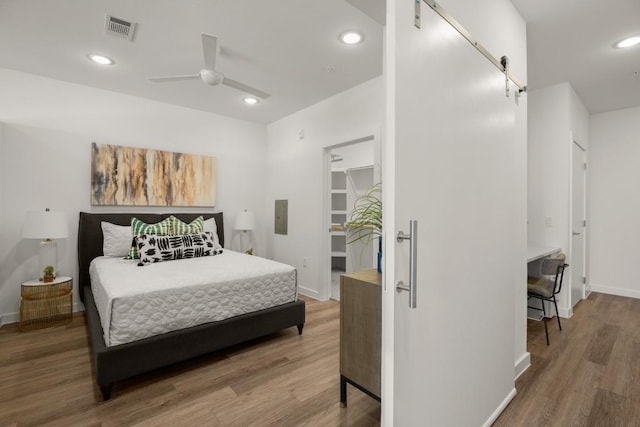 6324 N Lamar Blvd Unit 313, Austin, TX 78752 - bedroom featuring wood finished floors, baseboards, a spacious closet, and recessed lighting