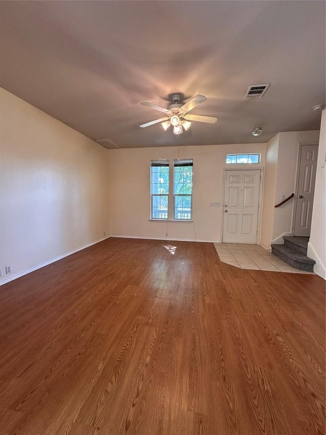 175A Michaelis Unit A, Kyle, TX 78640 - unfurnished living room with light wood-style floors, baseboards, a ceiling fan, and stairs