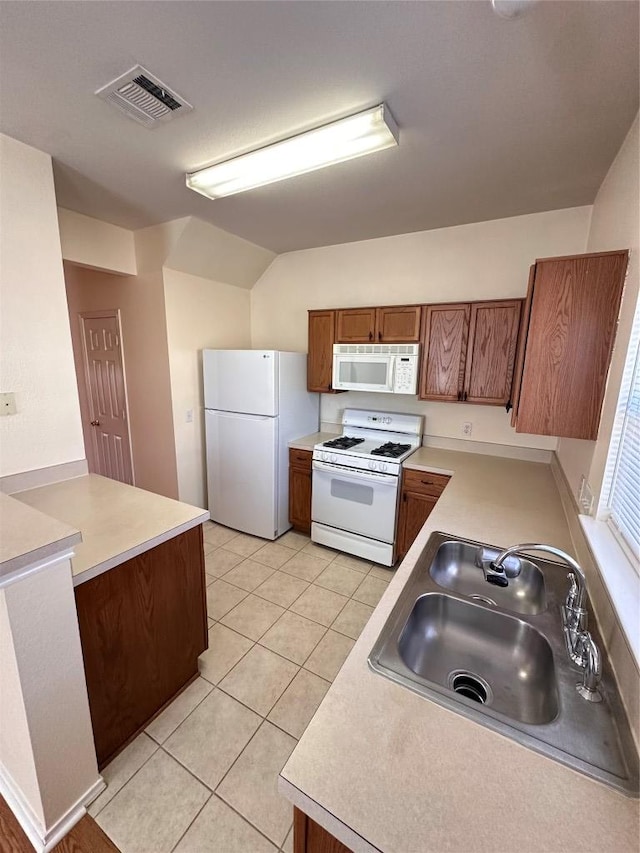 175A Michaelis Unit A, Kyle, TX 78640 - kitchen with white appliances, a sink, brown cabinets, light countertops, and light tile patterned flooring