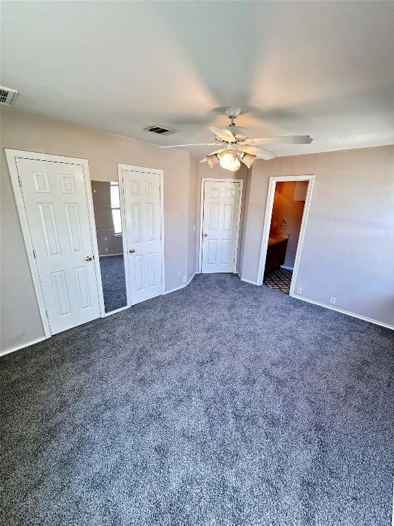 175A Michaelis Unit A, Kyle, TX 78640 - unfurnished bedroom with carpet floors, multiple closets, and baseboards