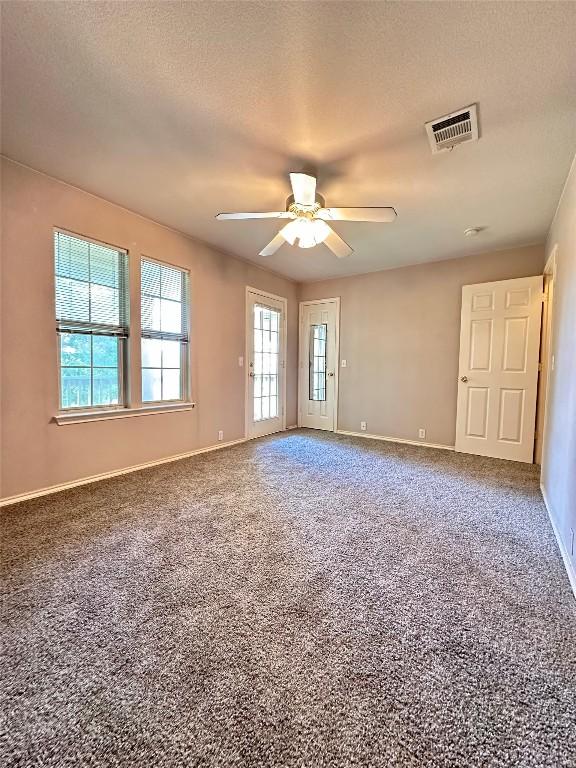 175A Michaelis Unit A, Kyle, TX 78640 - empty room featuring plenty of natural light, a ceiling fan, carpet floors, baseboards, and a textured ceiling
