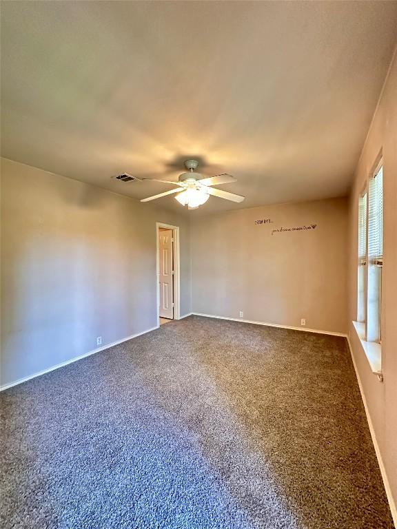 175A Michaelis Unit A, Kyle, TX 78640 - spare room with a ceiling fan, dark carpet, and baseboards
