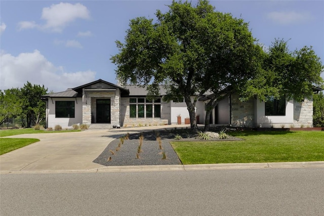 7817 Orisha Dr, Austin, TX 78739 - view of front of property with metal roof, stone siding, and a front lawn