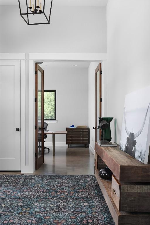 7817 Orisha Dr, Austin, TX 78739 - hallway featuring an inviting chandelier and baseboards