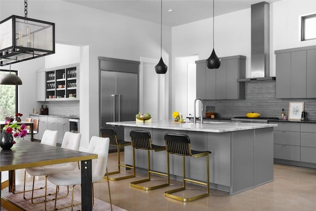 7817 Orisha Dr, Austin, TX 78739 - kitchen featuring wall chimney exhaust hood, modern cabinets, gray cabinets, appliances with stainless steel finishes, and decorative backsplash