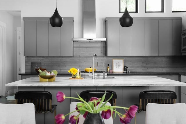 7817 Orisha Dr, Austin, TX 78739 - kitchen featuring gray cabinetry, wall chimney exhaust hood, and modern cabinets