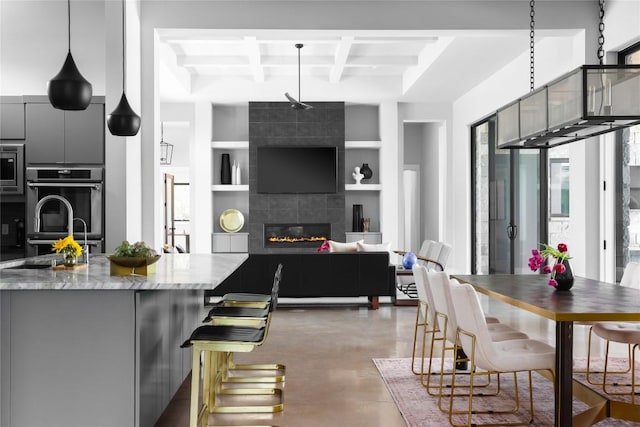 7817 Orisha Dr, Austin, TX 78739 - kitchen with beamed ceiling, concrete floors, coffered ceiling, gray cabinetry, and built in shelves