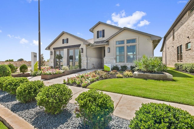 exterior space featuring stucco siding, stone siding, and a lawn