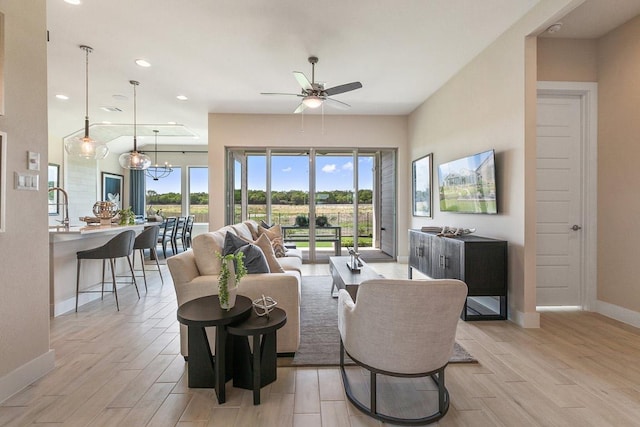 living area with light wood-type flooring, ceiling fan, baseboards, and recessed lighting
