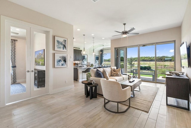 living room with french doors, light wood-style flooring, a ceiling fan, and recessed lighting