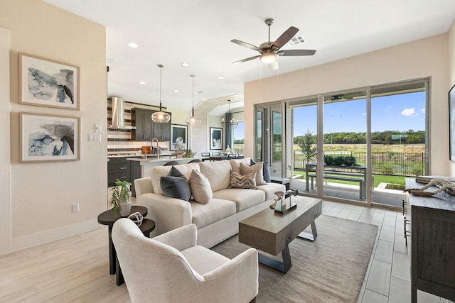living room with recessed lighting, light wood-style flooring, baseboards, and ceiling fan