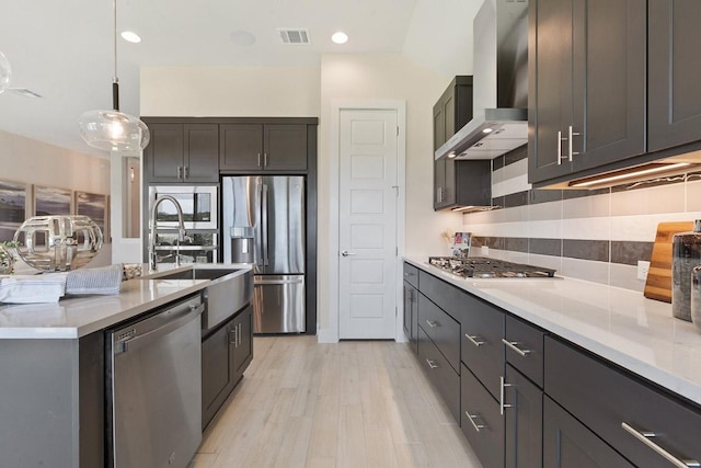 kitchen with light countertops, backsplash, visible vents, wall chimney exhaust hood, and appliances with stainless steel finishes