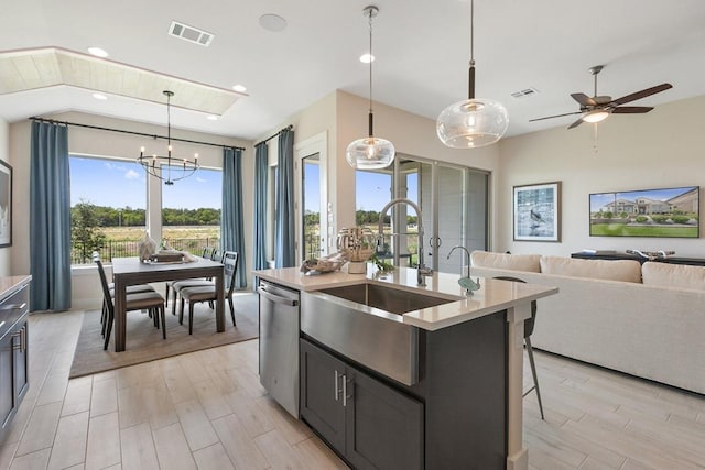 kitchen with open floor plan, stainless steel dishwasher, a sink, and visible vents