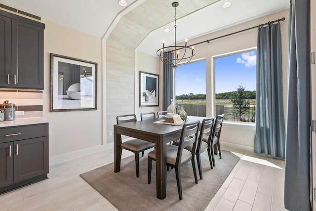 dining area featuring baseboards, recessed lighting, an inviting chandelier, and light wood-style floors