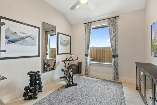 exercise area featuring light wood-type flooring, baseboards, a ceiling fan, and lofted ceiling