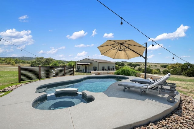 view of swimming pool featuring a patio area, fence, and a pool with connected hot tub