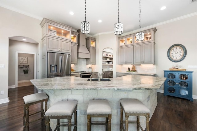 kitchen featuring baseboards, a sink, a breakfast bar, stainless steel appliances, and decorative backsplash