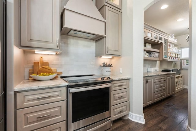 kitchen with glass insert cabinets, tasteful backsplash, premium range hood, stainless steel electric range, and dark wood-style floors