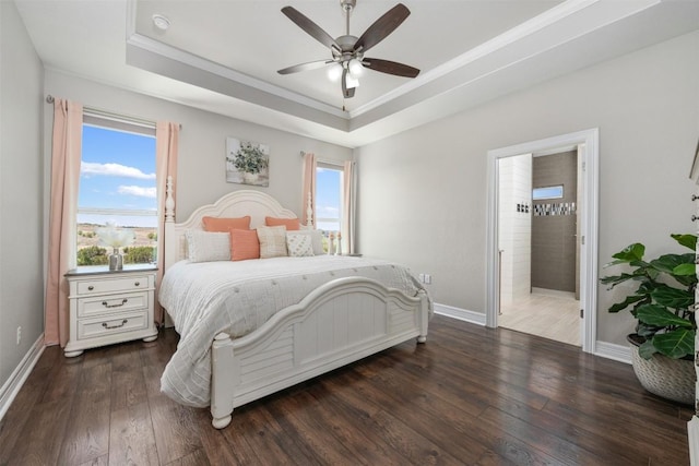bedroom featuring baseboards, a tray ceiling, ornamental molding, and wood finished floors