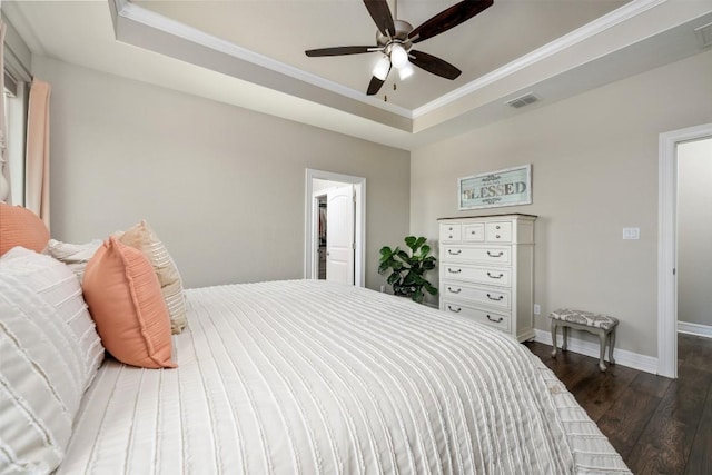 bedroom with a raised ceiling, ornamental molding, baseboards, and dark wood-style floors