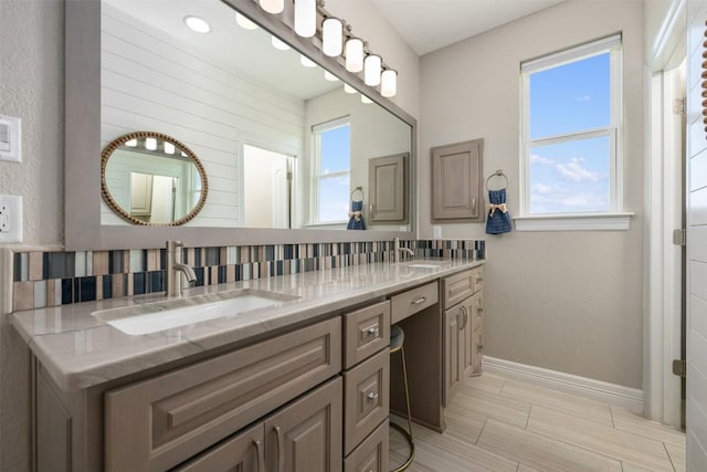 full bathroom featuring tasteful backsplash, double vanity, a sink, and baseboards
