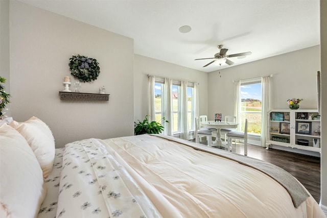 bedroom featuring access to outside, a ceiling fan, and wood finished floors