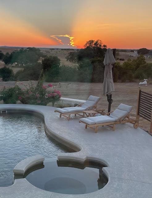 surrounding community featuring a patio, a swimming pool, and a hot tub