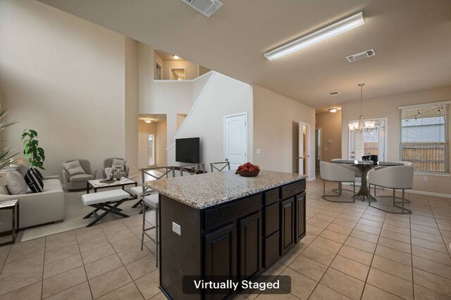 kitchen featuring open floor plan, light tile patterned floors, visible vents, and an inviting chandelier